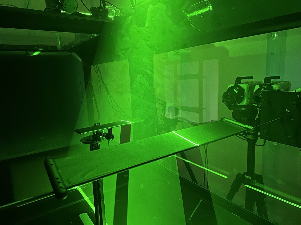 The surfing wing and upstream wake generator under laser illumination in the test section